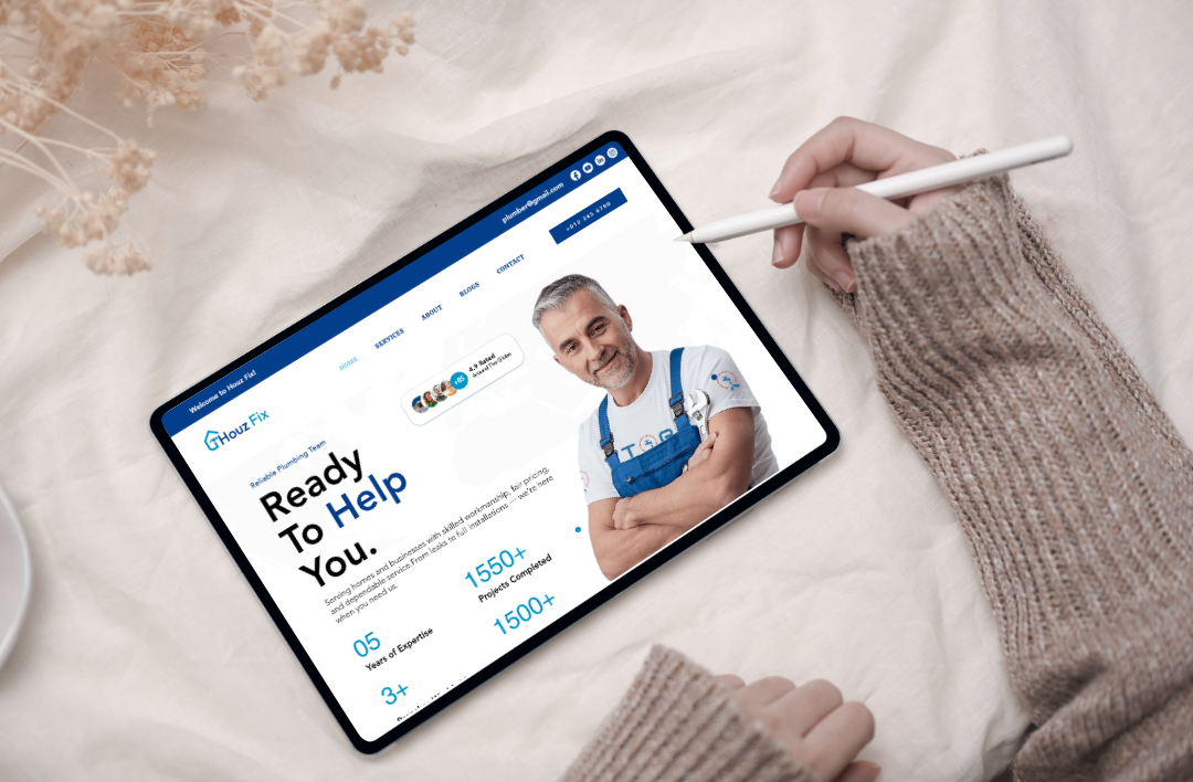 A top-down lifestyle mockup of a Wix-based plumbing website for 'Houz Fix' displayed on a tablet. The screen features a clean blue and white UI with a professional plumber's image, the headline 'Ready To Help You,' and key business stats like 1550+ completed projects. The tablet is set against a minimalist background of soft beige fabric and dried flowers, highlighting a premium and modern approach to home maintenance services.
