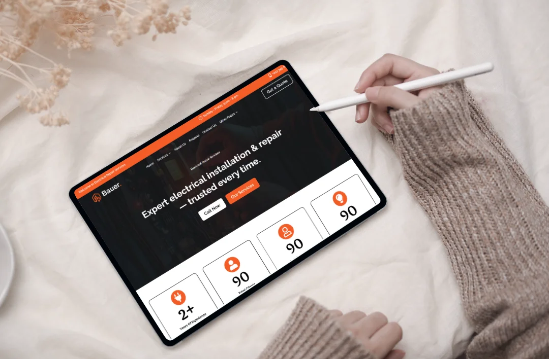 Tablet displaying an electrician WordPress website homepage with electrical installation and repair services and call-to-action buttons.