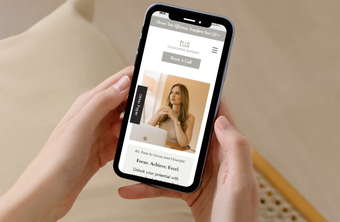 Close-up lifestyle mockup of a person holding a smartphone displaying the 'Productivity Coach' website template. Features a minimalist mobile design with a 'Book A Call' button and professional portrait. High-quality responsive layout.