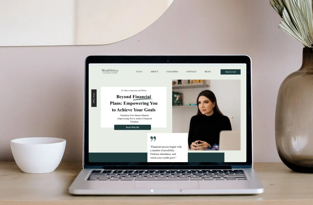 A professional laptop mockup of a 'Financial Coaching' website template on a light wooden desk. The screen features a dark green and white minimalist layout with a sophisticated coach portrait and clear call-to-action buttons. Styled with a white bowl and a glass vase with dried pampas grass in a bright room.